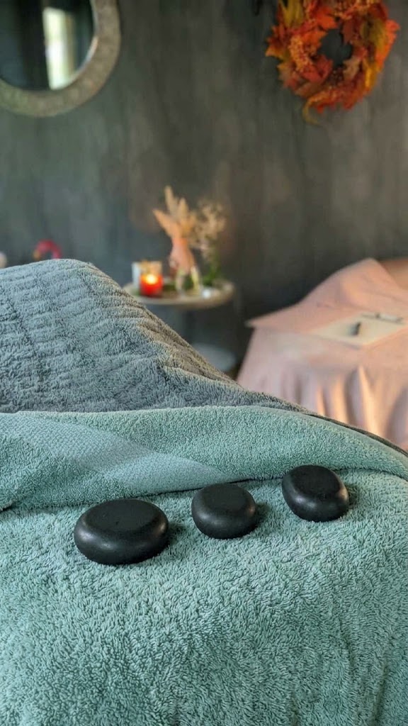 Heated basalt stones beside the treatment bed for a hot stone massage in Crowborough